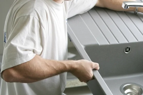 Person beim Einbau einer Spüle